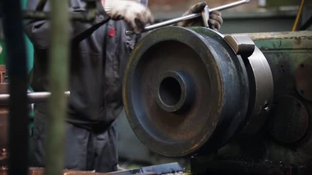 Un uomo lavora con una fresatrice - lavorando con una barra d'acciaio - girando la ruota — Video Stock