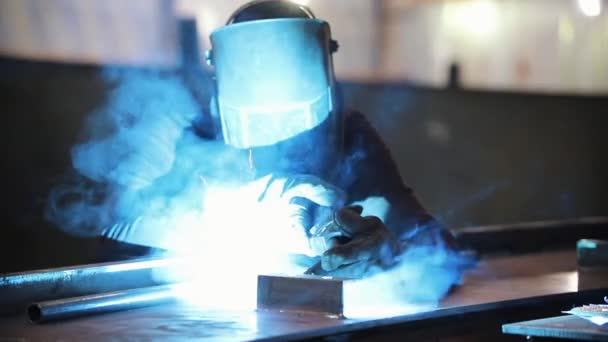 A man in a protective suit works with a welding machine. Bright light — Stock Video