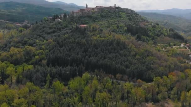 Widok z lotu ptaka na las. Droga między drzewami. W górach można zobaczyć miasto. Włochy, Toskana. — Wideo stockowe