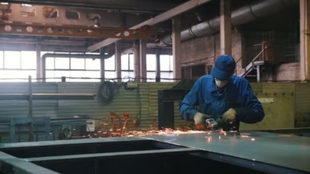 Průmyslový stavební závod. Muž s brusným strojem. Broušení strany detailu. — Stock video