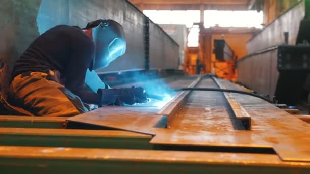A man in a protective working with welding machine. The camera approaches him. — Stock Video
