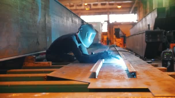 The man works as a welding machine. The camera moves smoothly alongside. — Stock Video