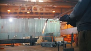 Bir adam kaynak makinesinde basıncı düzenler.