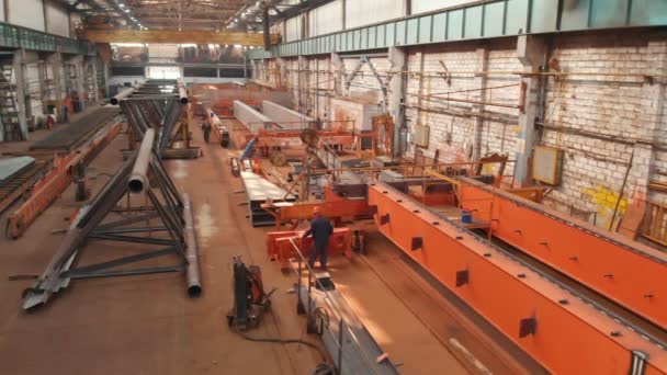 Un homme contrôle le mouvement de la partie métallique de la grue attachée — Video