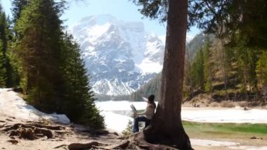 Dolomites. Ağaca eğilmiş bir tuval üzerine çizim genç bir kadın