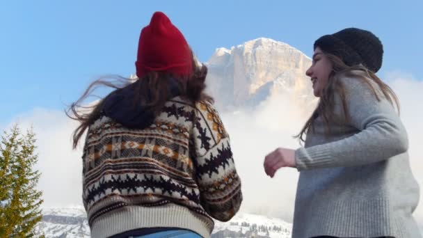 İki genç seyahat eden kadın dağlara koşup bir resmini çekerken — Stok video