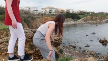 İki genç kadın taş kıyıya gider