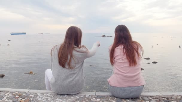 Duas jovens amigas sentadas nas escadas perto do mar — Vídeo de Stock