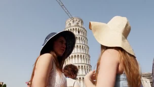 Ιταλία, Πίζα. Δύο νεαρές γυναίκες στα πανοράματα στέκονται μπροστά από τον πύργο της Πίζας και μιλούν κοιτάζοντας το — Αρχείο Βίντεο