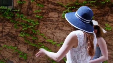 İki genç kadın yaz havalarda sokaklarda panamalar yürüyüş