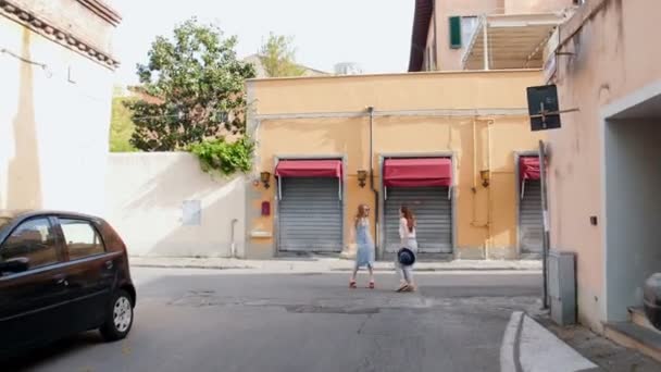 Două tinere care călătoresc fericite stând pe străzile galbene — Videoclip de stoc