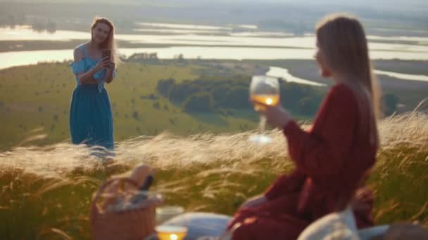 Žena, která fotografují svého přítele, zatímco mají piknik na hřišti — Stock video