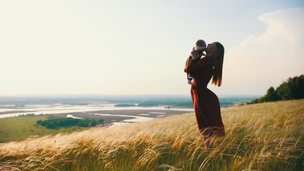 女性は彼女の腕の中に子供を保持しています。愛の抱擁を表現. — ストック動画