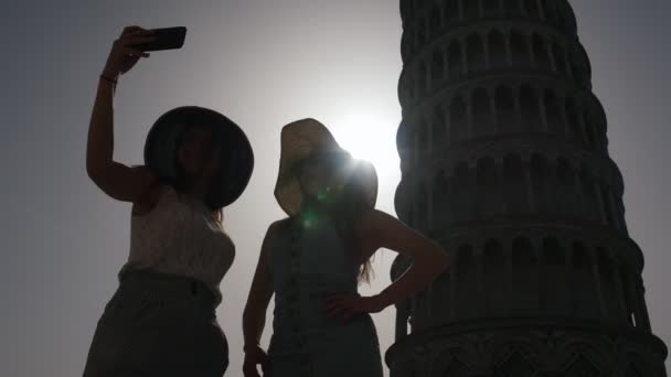 As silhuetas escuras de mulheres estão no fundo da Torre Inclinada. Itália - Pisa — Vídeo de Stock