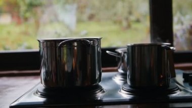 İki tencere brülör, buhar geliyor. Pencerenin arka planında