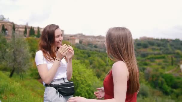 Dos mujeres jóvenes hablando y riendo en el fondo de la montaña — Vídeos de Stock