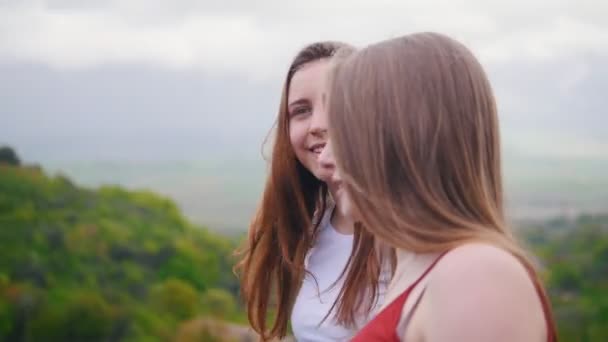 Δύο νεαρές γυναίκες πάνε να δούμε γύρω. Στο φόντο του τοπίου — Αρχείο Βίντεο