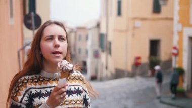 Kadın şehirde dondurma yiyor.