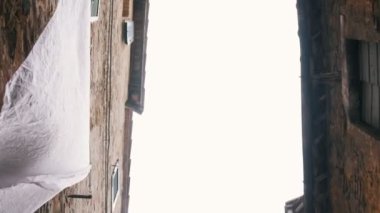 Dar bir sokakta kurutucu üzerinde keten. Aşağıdan çekim