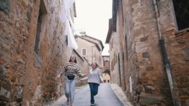 İki kadın birbirlerinin arkasındaki Lane boyunca koşmak