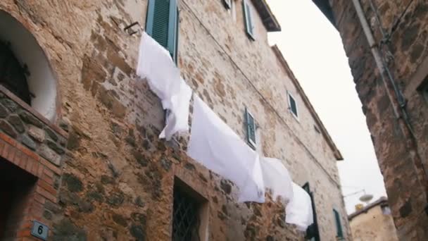 Weiße Bettwäsche hängt am Trockner unter den Fenstern — Stockvideo