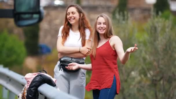 Twee jonge lachende vrouwen praten op straat. — Stockvideo