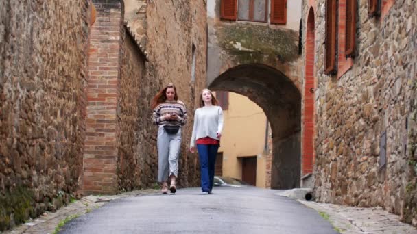 Frauen gehen eine schmale Straße entlang. Lachen und reden. — Stockvideo