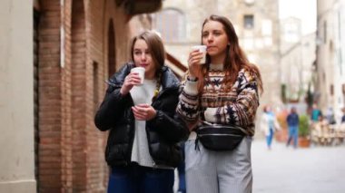 İki genç kadın sokaklara yürür. İnsanlar geçer