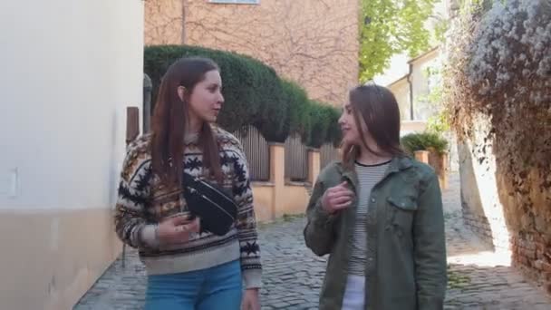 Duas jovens caminhando nas ruas estreitas e conversando — Vídeo de Stock