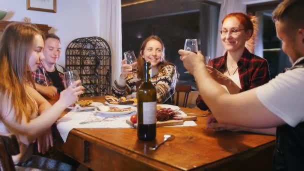 Des amis s'assoient à la table pour boire et parler — Video