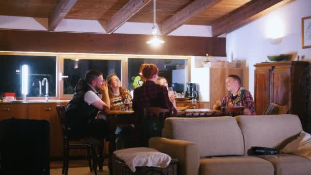 Une compagnie d'amis est assise à la table. Ils s'amusent et chantent la guitare — Video