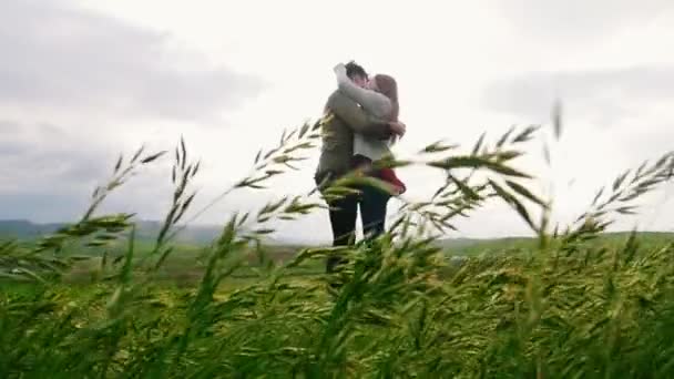 Mann und Frau umarmen sich inmitten eines Weizenfeldes. — Stockvideo