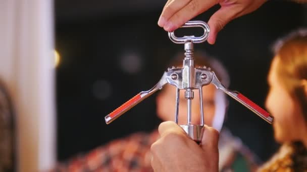 De man is het draaien van een kurkentrekker om de wijn te openen. — Stockvideo