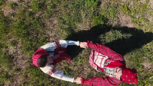 전통적인 러시아 옷을 입은 두 명의 여성이 위로 보고 춤을 추기 시작 - 카메라가 올라갑니다. — 비디오