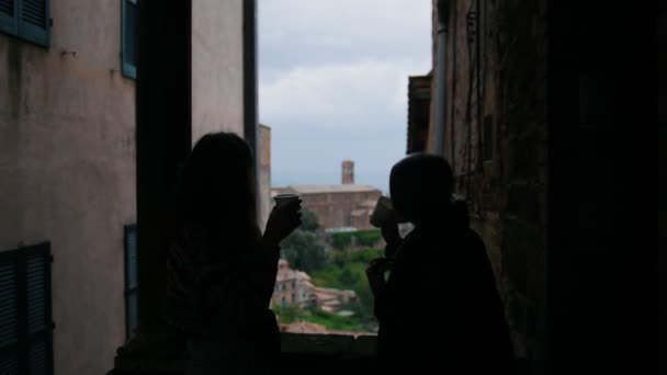 Due sagome scure di donne sono in piedi sul balcone e parlano — Video Stock