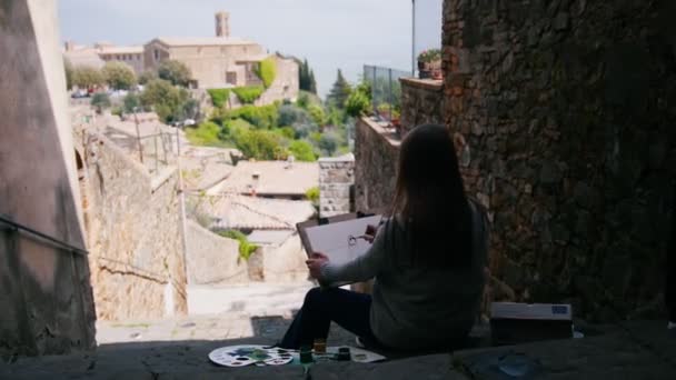 ผู้หญิงสาวที่น่าสนใจนั่งอยู่บนบันไดวาดรูปบ้าน . — วีดีโอสต็อก
