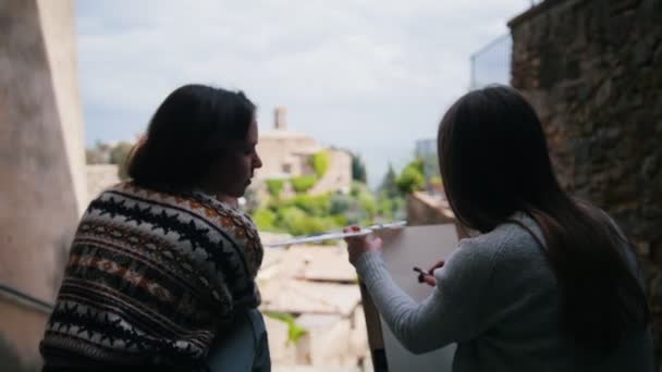 Twee vrouwen zittend bij de trap en bezig met creativiteit — Stockvideo