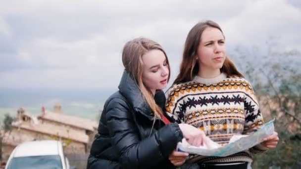 Twee jonge vrouwen controleren hun pad op de kaart. — Stockvideo