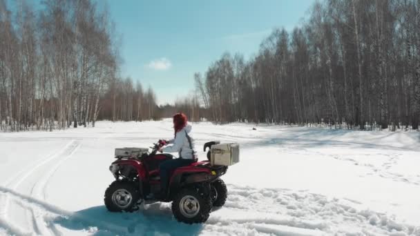 Kvinna kör en fyrhjuling på snöfältet. — Stockvideo