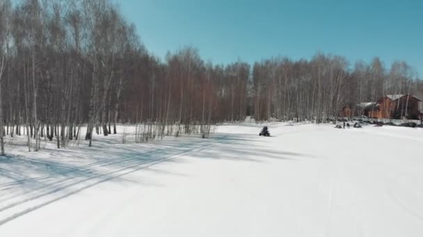 Чоловік їде на квадроциклі з жінкою на засніженому полі — стокове відео