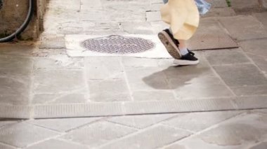İki genç kadın köşeden koşup sokakta yürüyor.