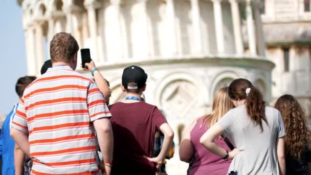 La gente se para en la torre inclinada de Pisa y tomar fotos de ella . — Vídeo de stock