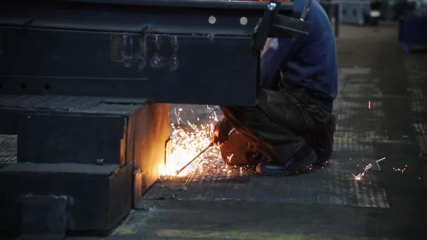 保護スーツを着た男性が金属工事の下で溶接. — ストック動画