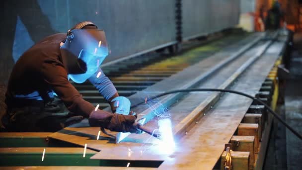 Um homem em um terno protetor solda a construção de metal . — Vídeo de Stock