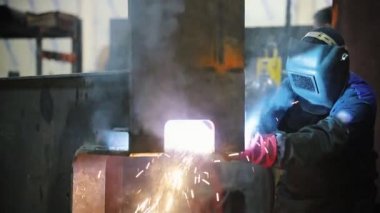 Bir adam bir brülör ile çalışır - kaynak bir metal köşe