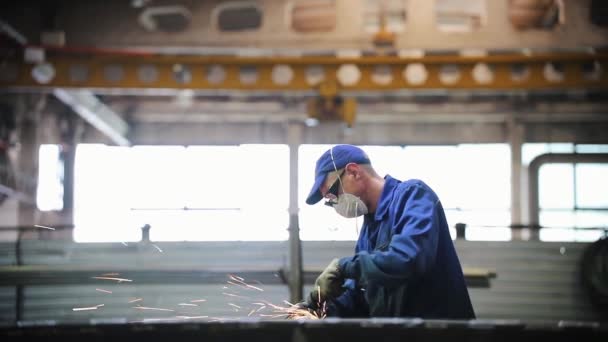 Ein Mann poliert in der Fabrik eine Metalloberfläche — Stockvideo