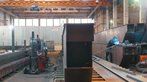 Плавний огляд металевих конструкцій на території заводу. Зварювальник з'являється в кадрі . — стокове відео