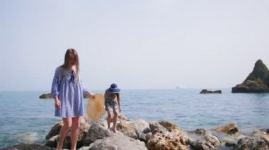 Plaj kıyafetleri iki güzel kadın Sorrento taşlı kıyı boyunca yürümek