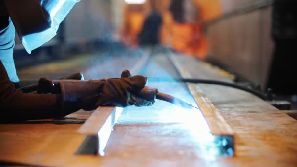 A man in a protective suit is engaged in welding items. Camera move from left to right. — Stock Video