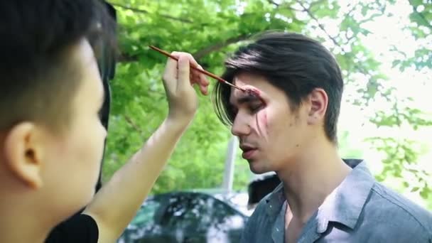 Backstage att tillämpa makeup för zombie apocalypse skytte. En trasig ögonbryns — Stockvideo